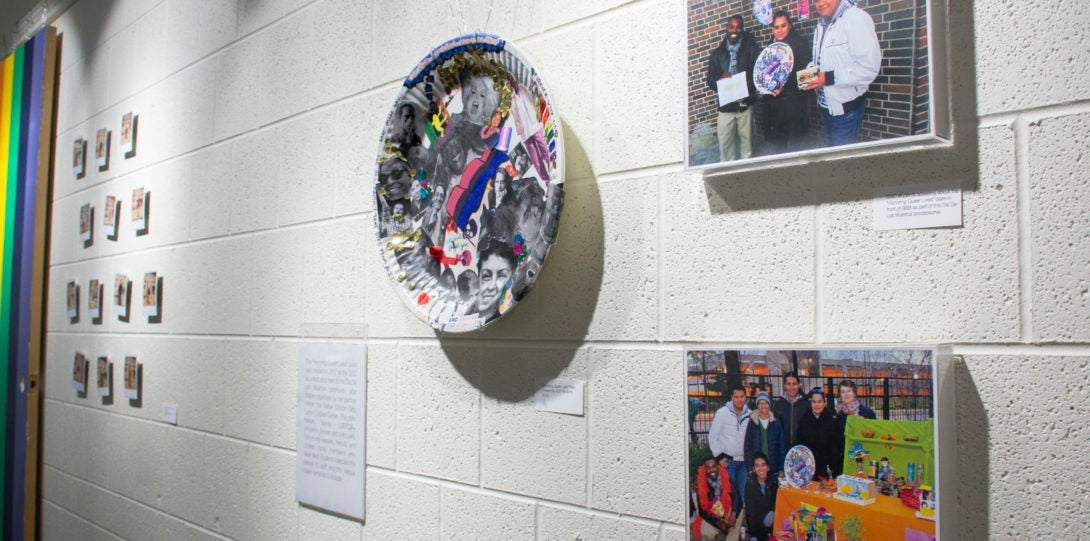 Photograph of Polaroids, a collage plate, and other photographs on a white wall