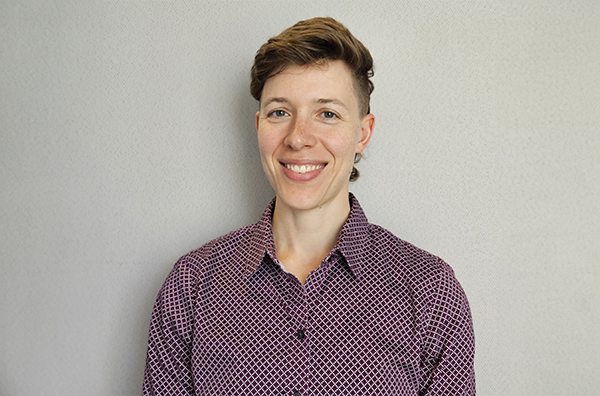 Autumn smiling wearing a maroon shirt in front of a white background