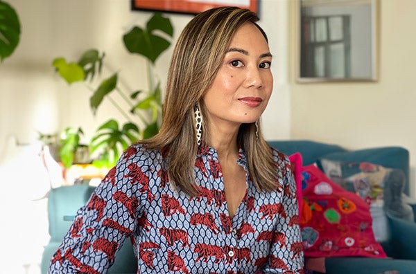 Kim wearing blouse with tigers on it. Couch and plants in the background.